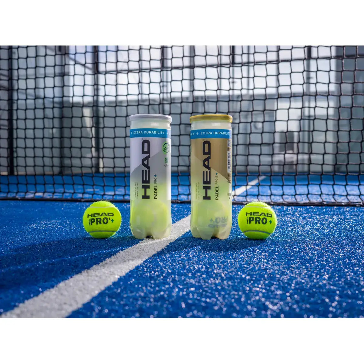 dos botes de bola head en pista con una bola a cada lado con la red de fondo